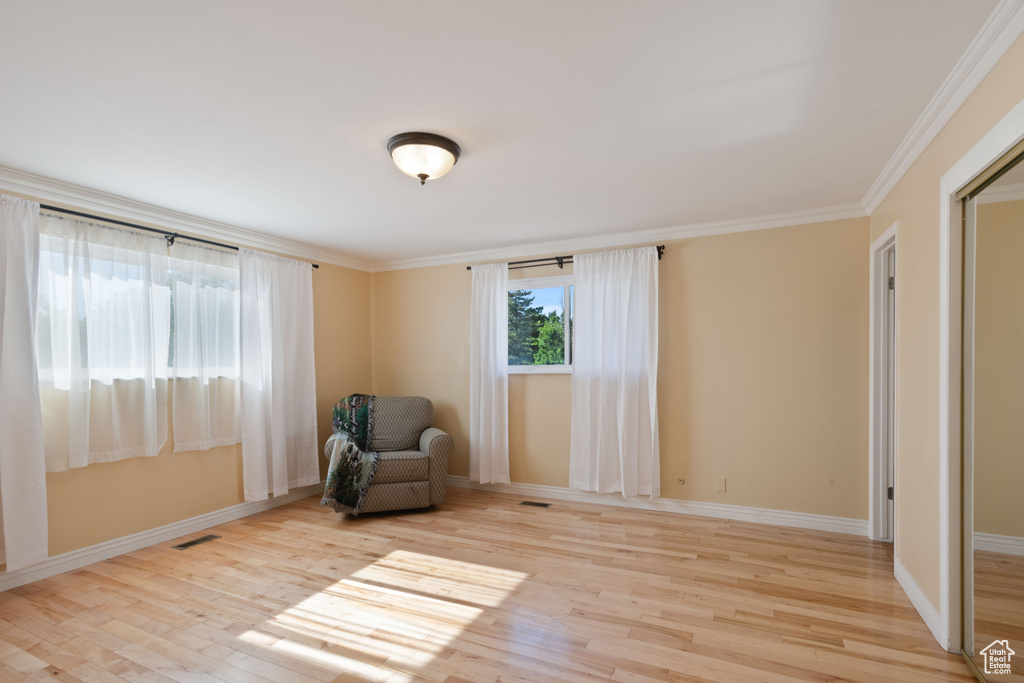 Unfurnished room with wood finished floors, baseboards, and ornamental molding