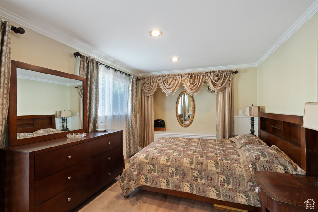 Bedroom featuring crown molding, wood finished floors, and recessed lighting