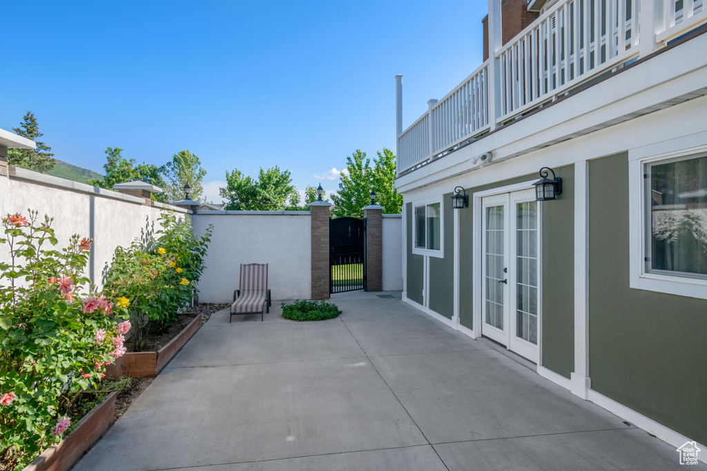 View of patio / terrace featuring french doors, a balcony, and a gate