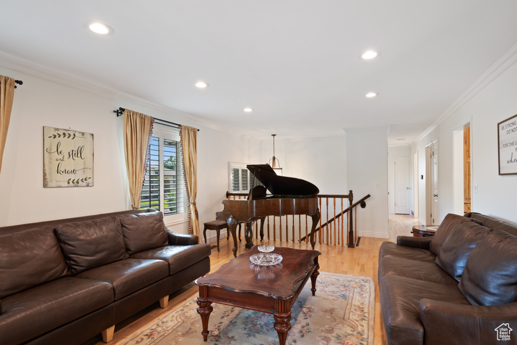 Living room with recessed lighting, crown molding, and light wood-style floors