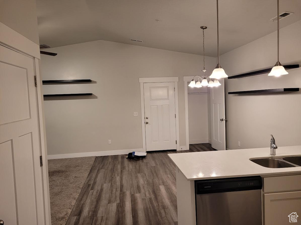 Kitchen with dishwasher, a sink, lofted ceiling, dark wood-style floors, and decorative light fixtures