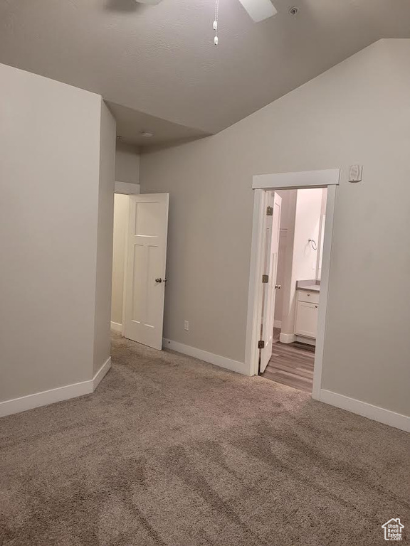 Carpeted spare room with baseboards and lofted ceiling