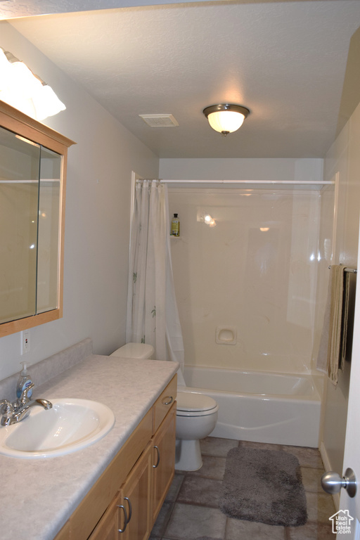 Bathroom with vanity, toilet, and shower / bath combo