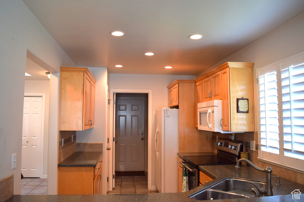 Kitchen featuring white appliances, recessed lighting, a sink, healthy amount of natural light, and light tile patterned flooring