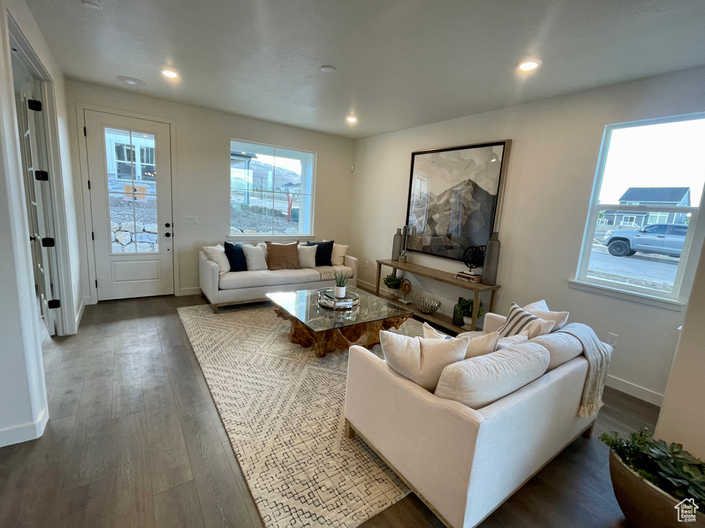 Living area featuring dark wood finished floors, recessed lighting, and baseboards