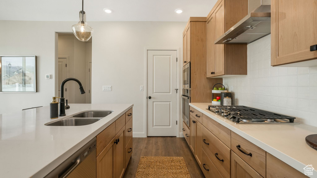 Kitchen with wall chimney range hood, appliances with stainless steel finishes, light countertops, decorative backsplash, and recessed lighting