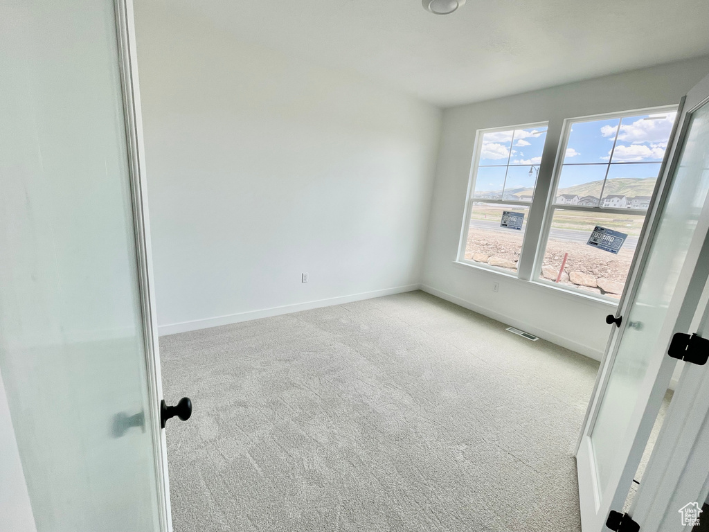 Carpeted spare room with baseboards