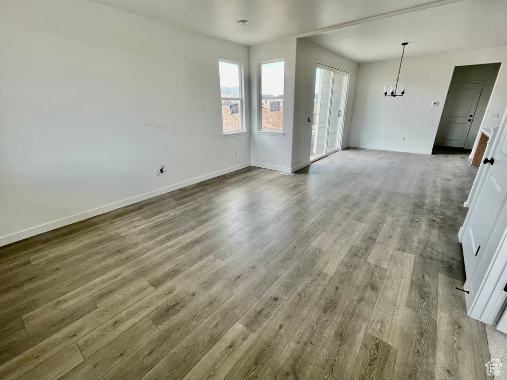 Empty room featuring a chandelier and wood finished floors