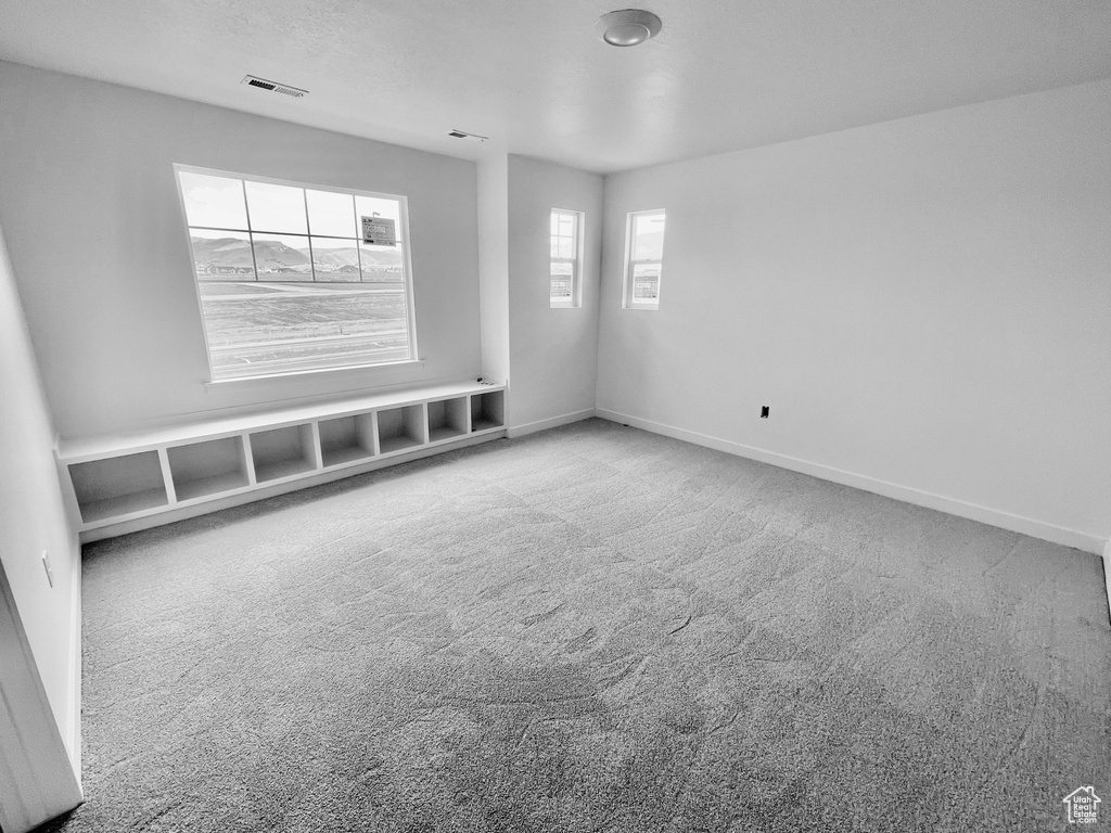 Empty room featuring carpet and baseboards