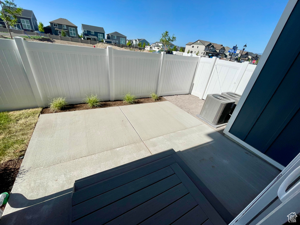 Fenced backyard featuring a residential view, a patio area, and central AC