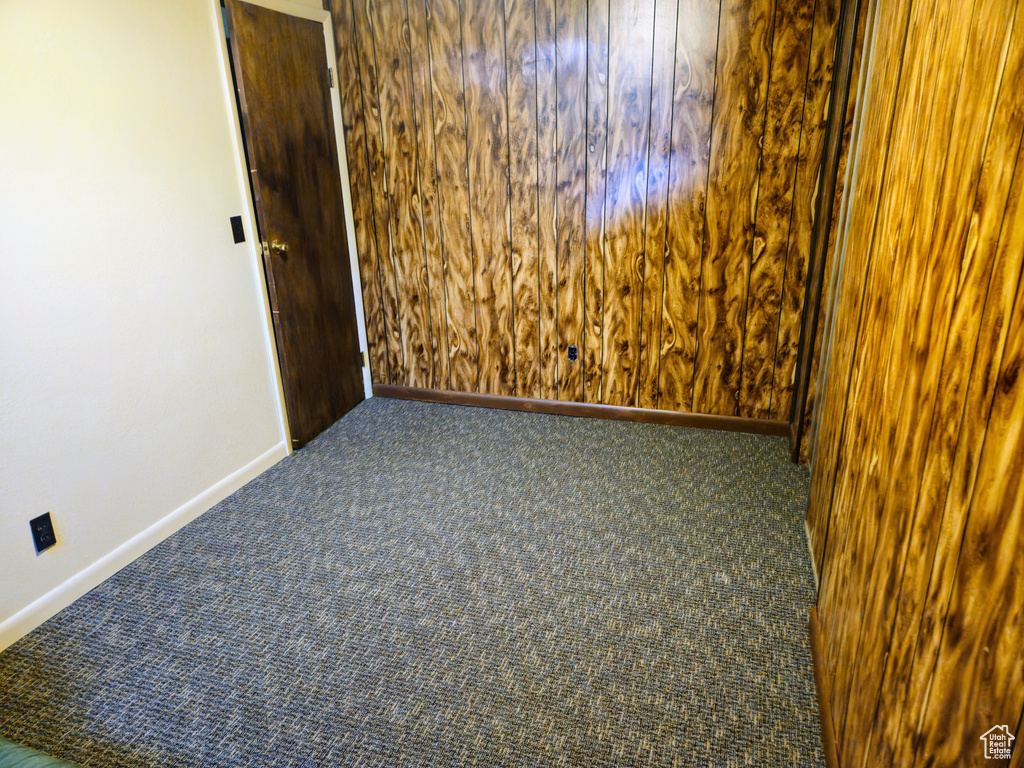 Carpeted spare room featuring baseboards