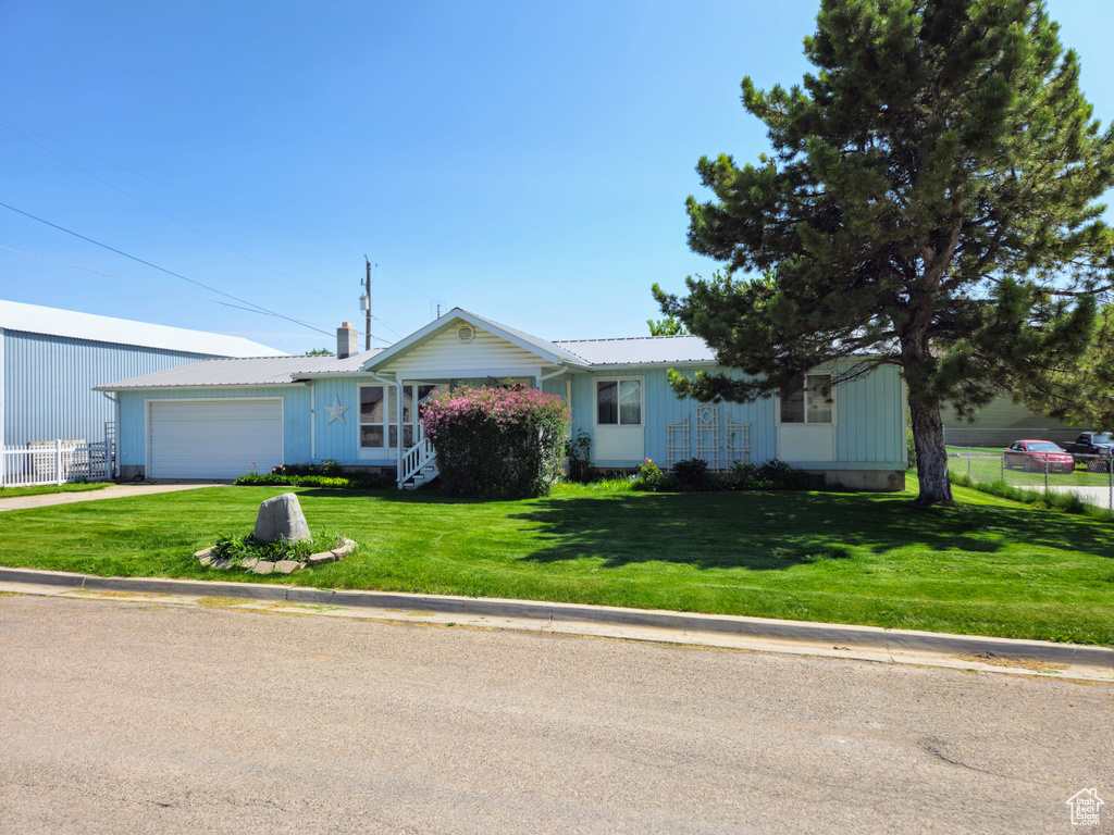 Ranch-style house featuring a garage, driveway, and board and batten siding
