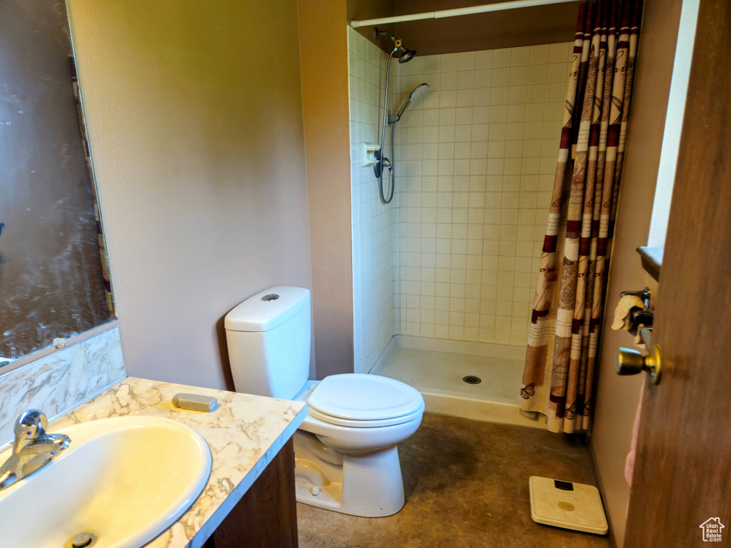 Full bathroom with toilet, a tile shower, and vanity
