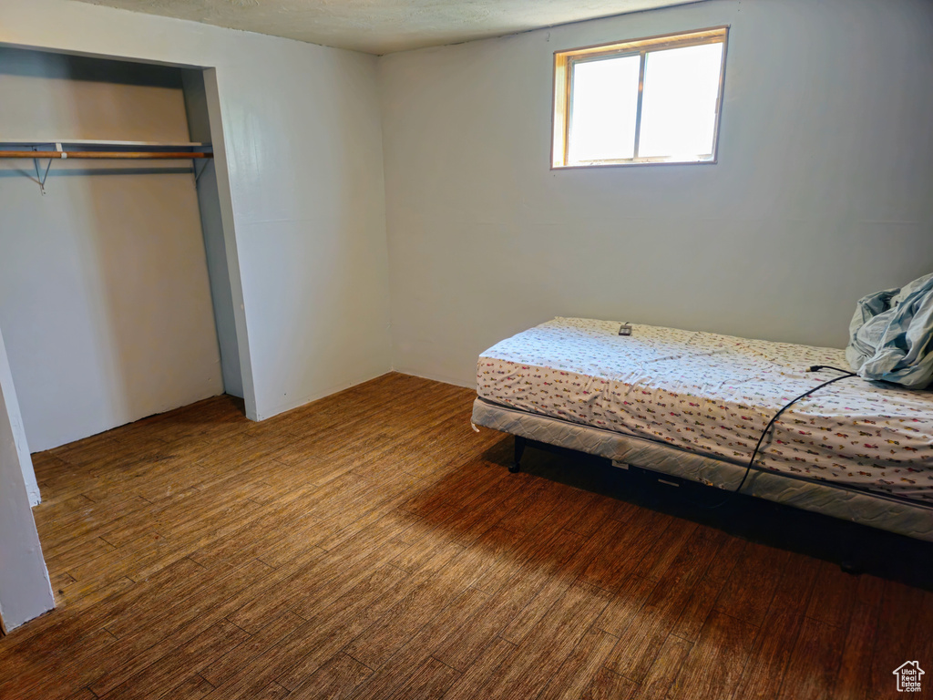 Bedroom with wood finished floors and a closet