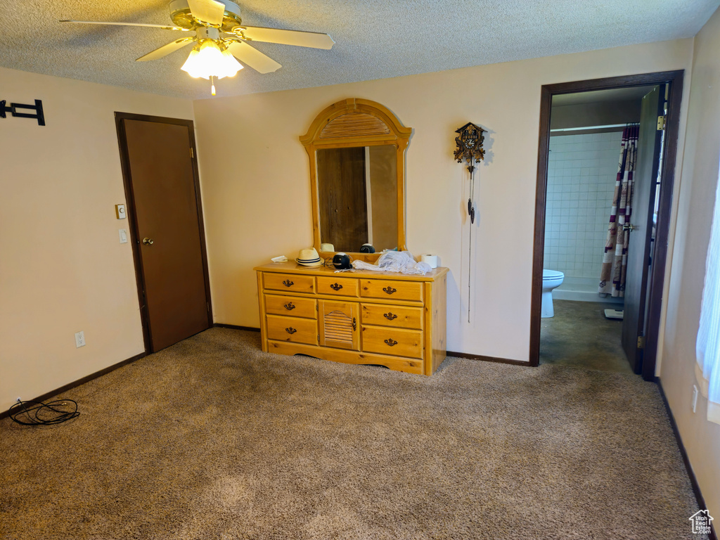 Bedroom featuring a textured ceiling, carpet, ensuite bathroom, and a ceiling fan