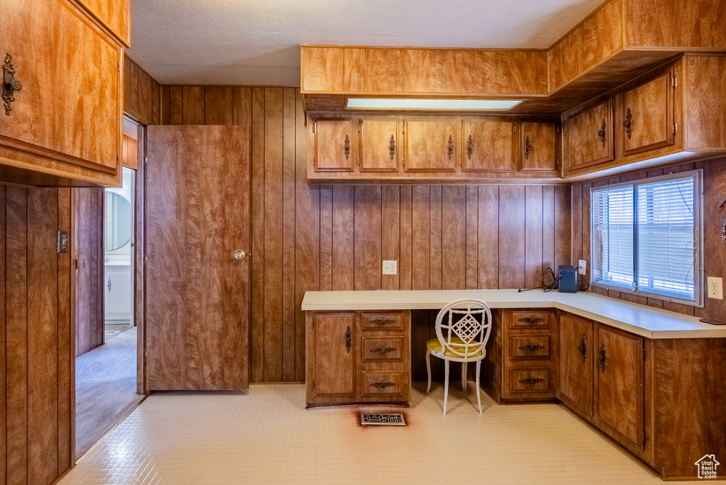 Home office with built in study area and wooden walls