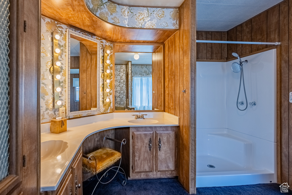 Full bathroom featuring double vanity and a shower stall