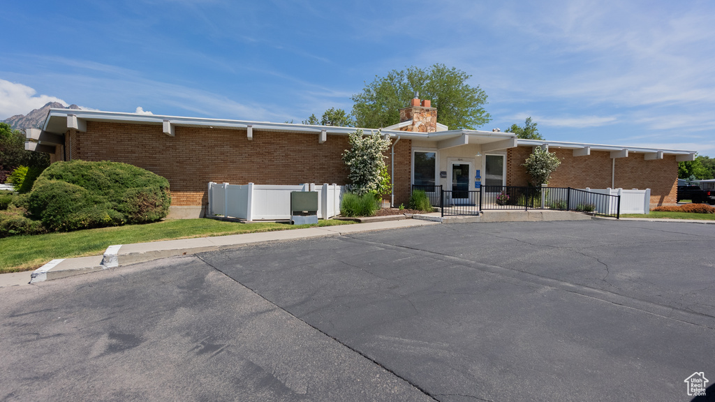 View of front of home featuring a chimney and brick siding