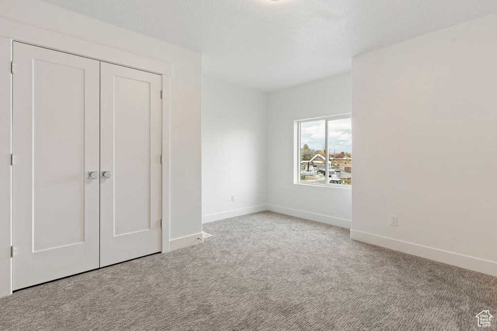 Unfurnished bedroom with carpet, baseboards, and a closet