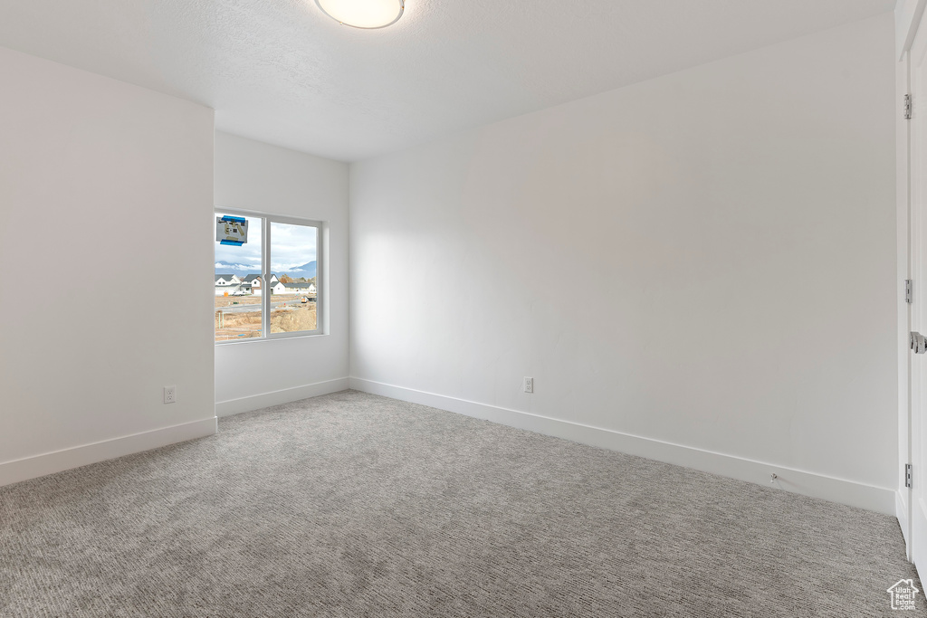 Carpeted empty room with baseboards