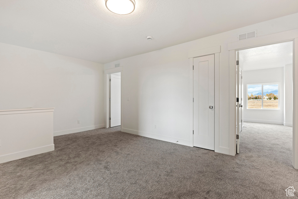 Carpeted empty room with baseboards