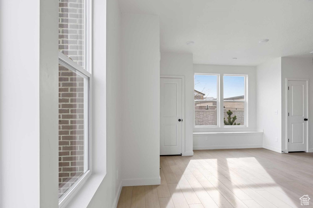 Hallway with baseboards and light wood-style floors
