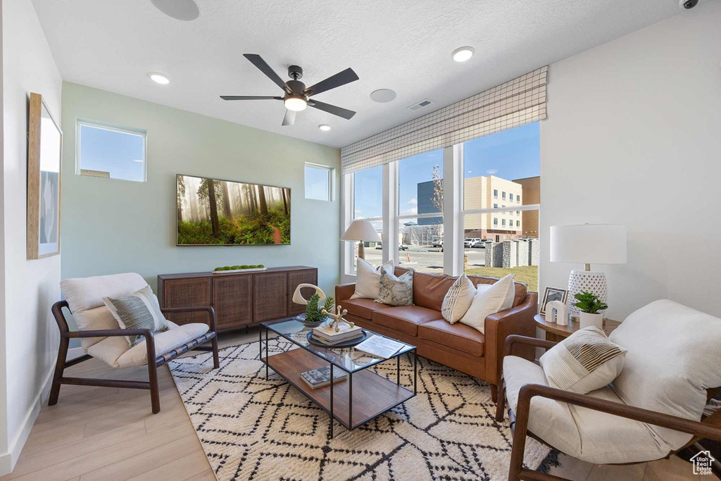 Living area featuring a ceiling fan, light wood-type flooring, baseboards, and recessed lighting