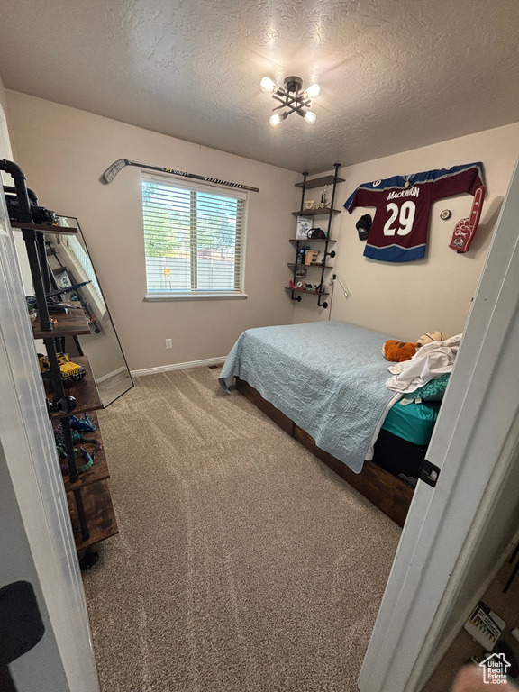 Bedroom featuring a textured ceiling, carpet, and baseboards