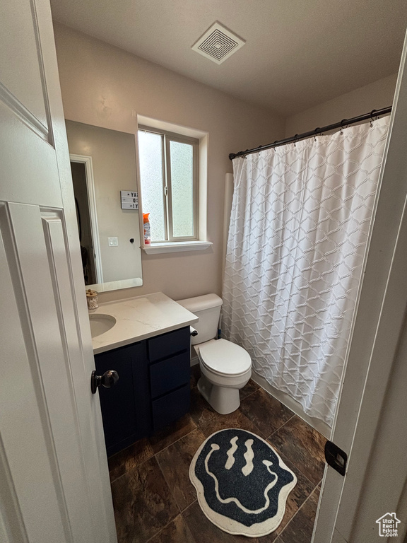Bathroom with vanity, toilet, and a shower with curtain