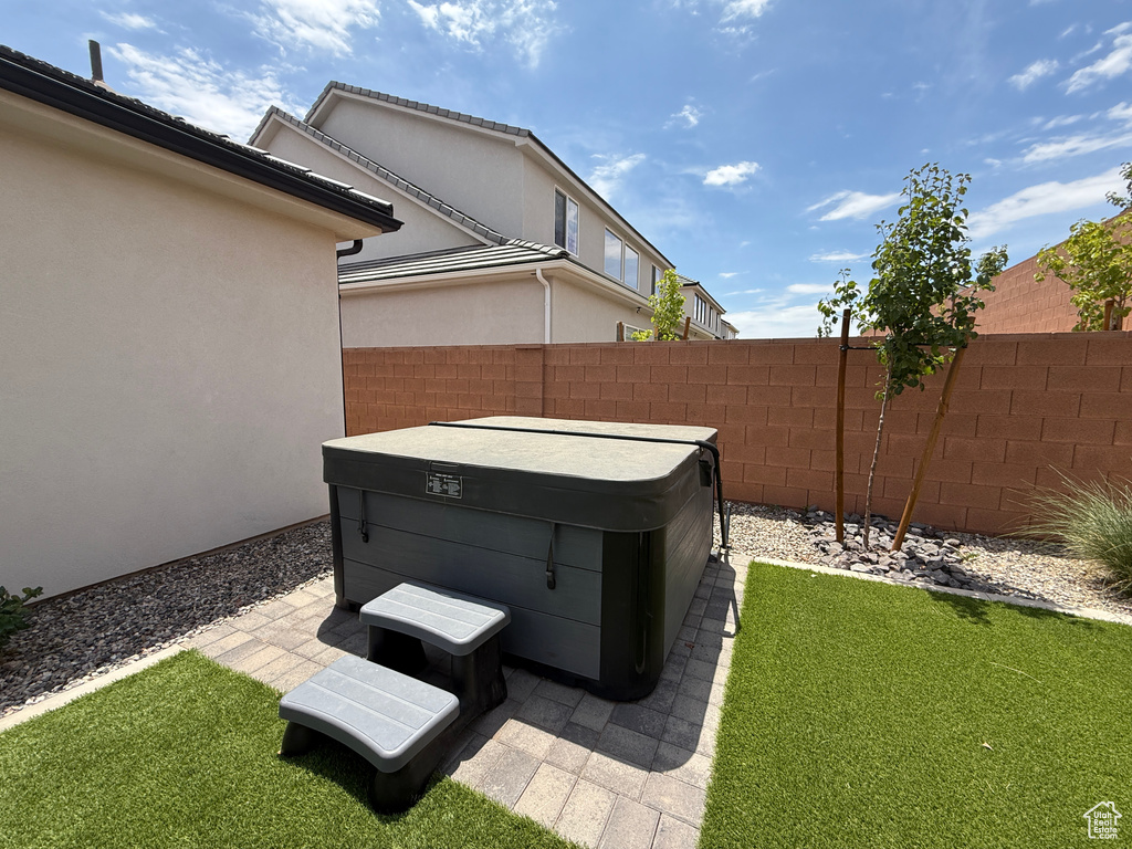 View of yard featuring a hot tub and a patio area