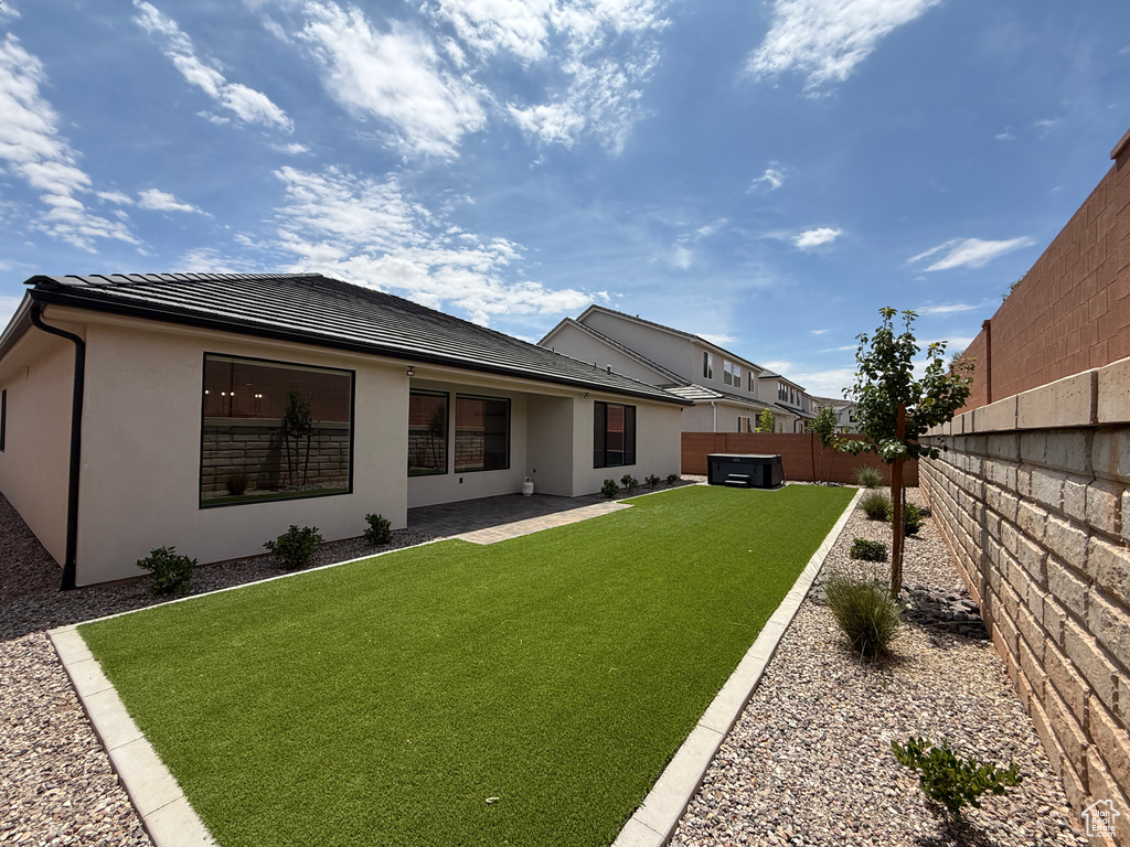 Rear view of house featuring stucco siding and a tiled roof