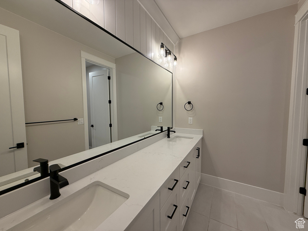Bathroom with tile patterned floors, double vanity, and baseboards