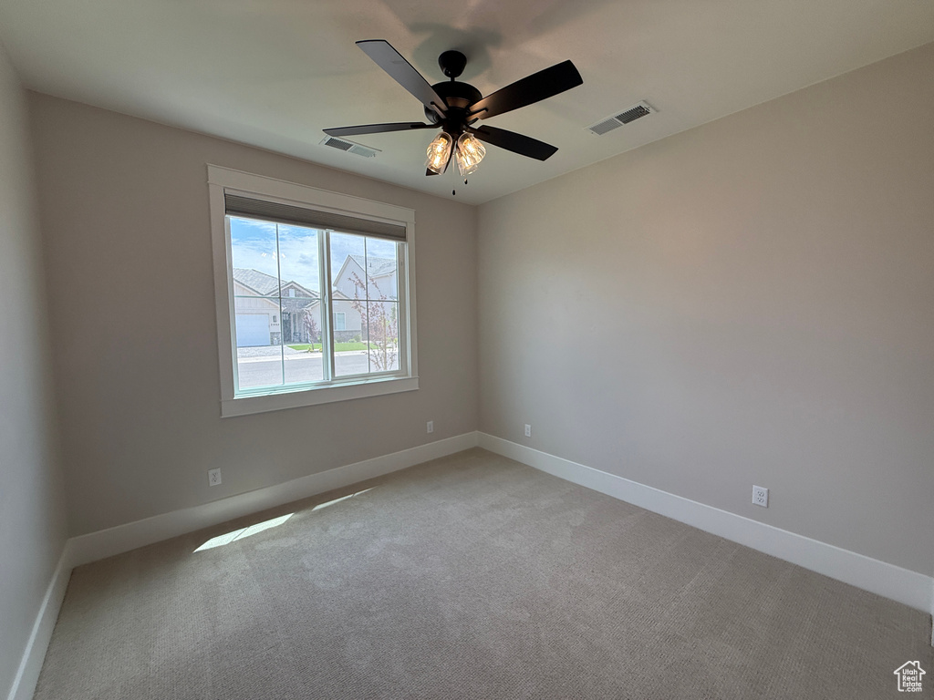 Empty room with light carpet, baseboards, and ceiling fan