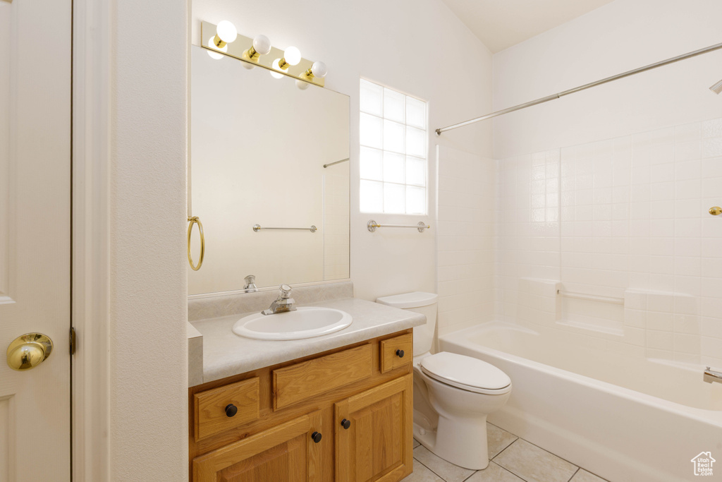 Bathroom featuring vanity, tile patterned floors, toilet, and shower / bathtub combination