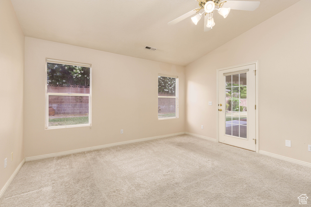 Empty room featuring carpet floors, vaulted ceiling, baseboards, and ceiling fan