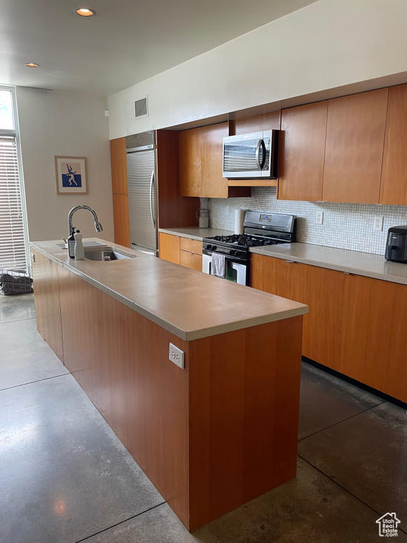 Kitchen featuring stainless steel appliances, a sink, backsplash, light countertops, and modern cabinets