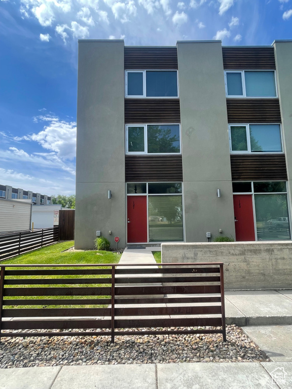 View of building exterior featuring a fenced front yard