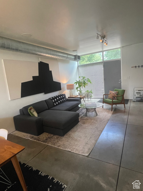 Living room featuring rail lighting and finished concrete flooring
