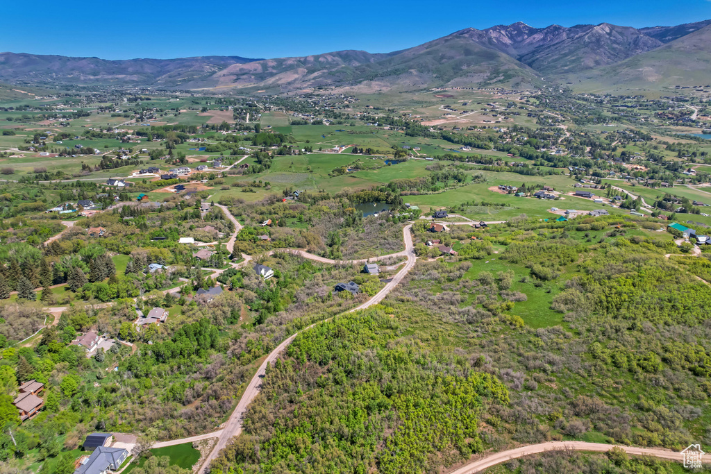 Aerial view of property and surrounding area with a mountain backdrop