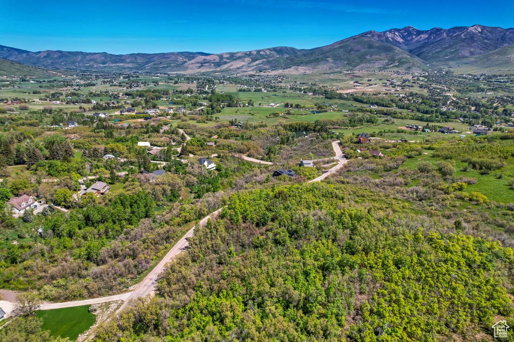 Aerial view of property and surrounding area with a mountain backdrop