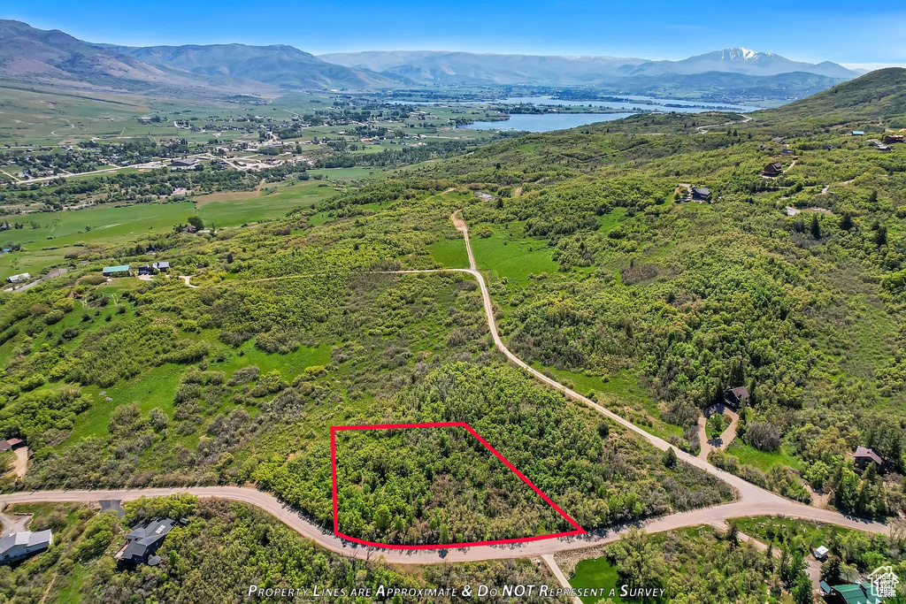 Aerial view of property's location featuring a water and mountain view and property parcel outlined