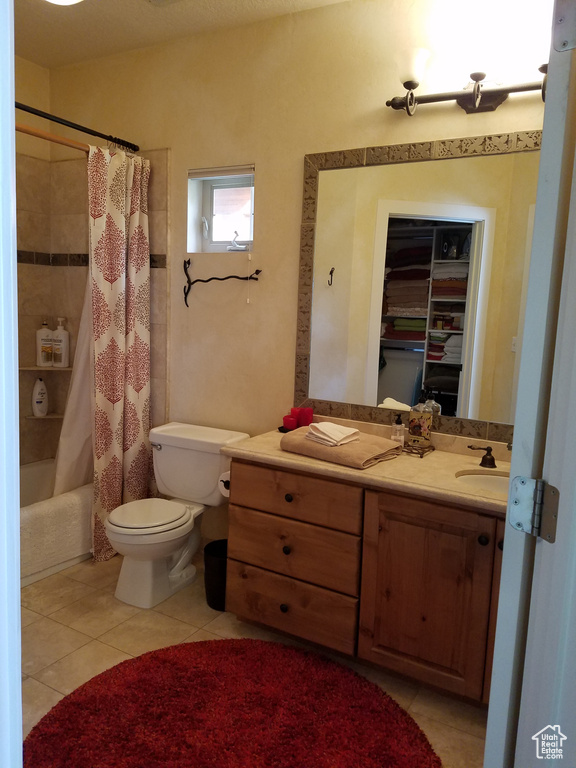 Bathroom featuring tile patterned floors, toilet, vanity, and shower / tub combo with curtain
