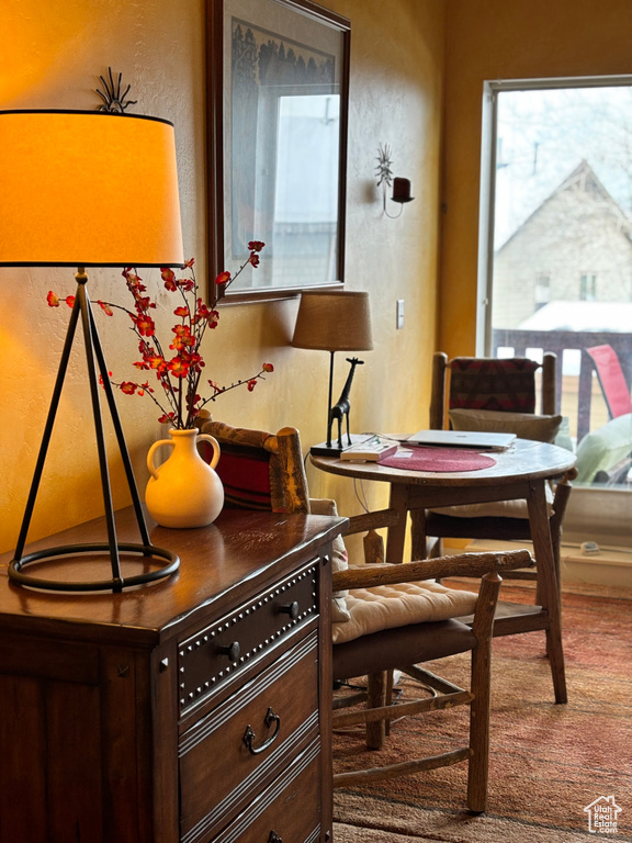 Carpeted dining space featuring a textured wall