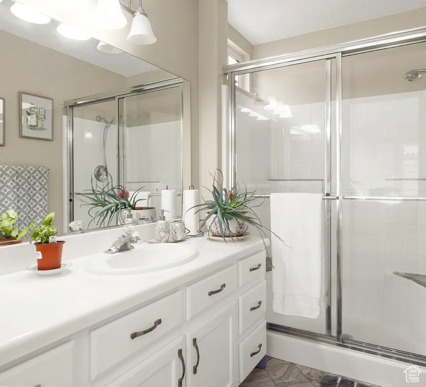Bathroom with vanity, a stall shower, and marble finish floors