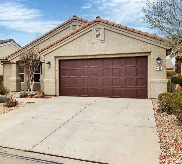 View of front of property with stucco siding, an attached garage, concrete driveway, and a tiled roof
