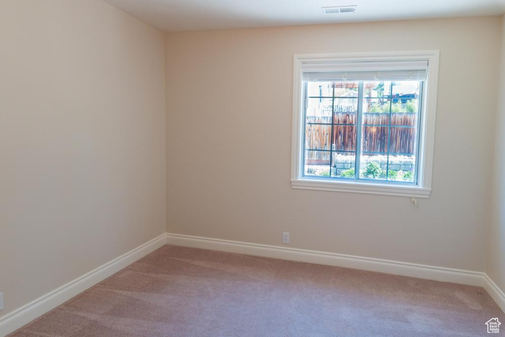 Carpeted empty room featuring baseboards