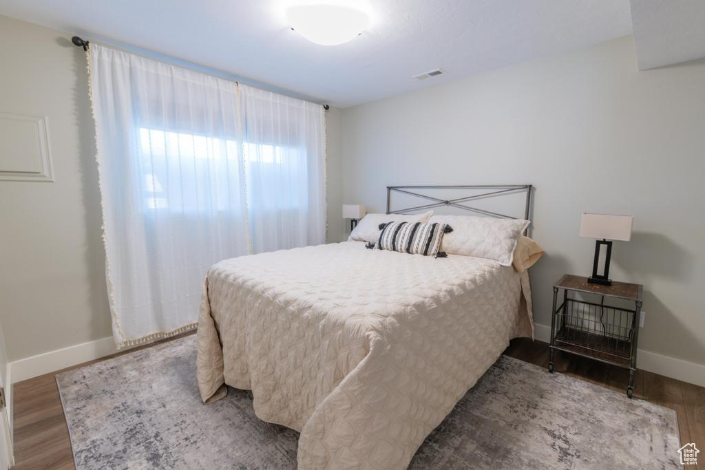 Bedroom with wood finished floors and baseboards