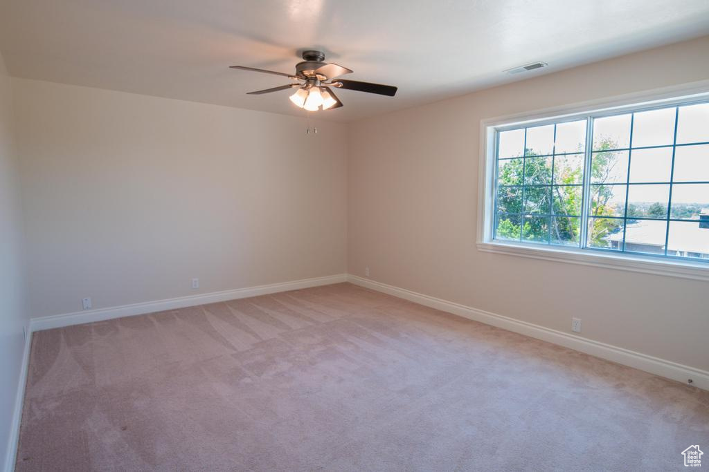 Unfurnished room with ceiling fan, light colored carpet, and baseboards