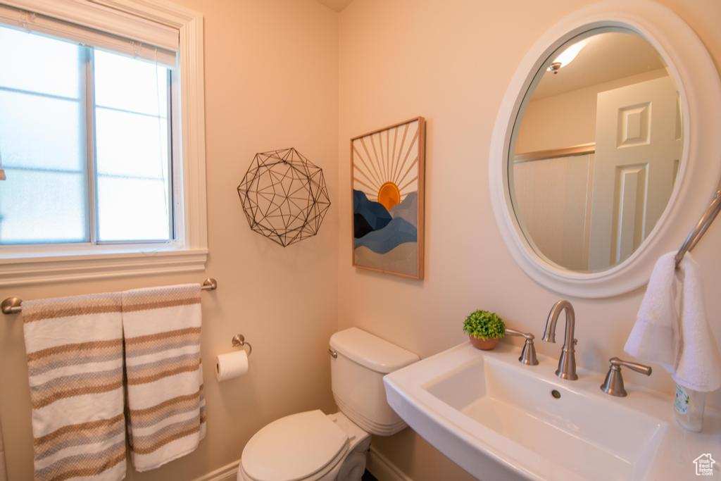 Bathroom with a sink, toilet, and healthy amount of natural light