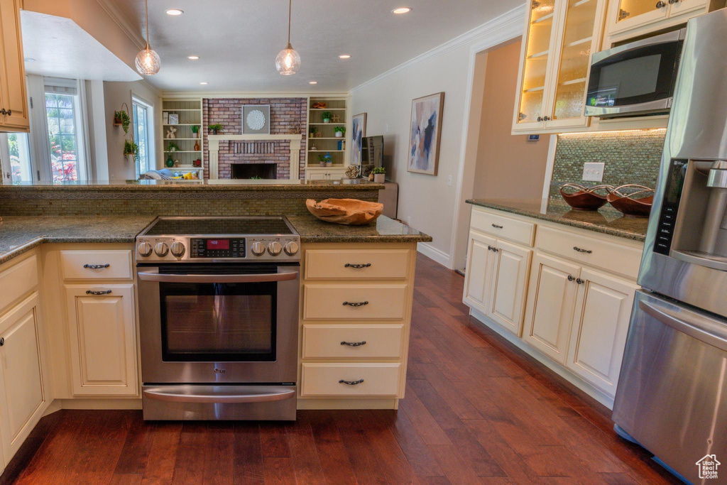 Kitchen with stainless steel appliances, crown molding, dark wood finished floors, backsplash, and glass insert cabinets